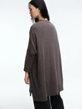 Cardigan de tejido de punto en color marrón, con diseño de silueta relajada, sisa caída, mangas ajustadas y bolsillos frontales.