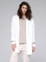 Spolverino blanco de tejido de punto, con bolsillos laterales y corte recto.