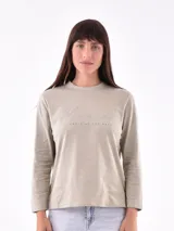 Remera de manga larga color beige, con cuello redondo y estampado frontal que dice "Magic is something you make" en color lila.