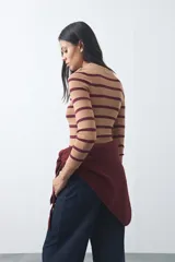 Polera de tejido rib al cuerpo con diseño de rayas horizontales en color bordó y celeste, cuello alto y manga larga.