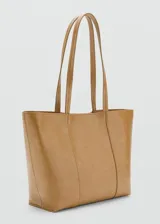 Bolso tipo shopper de tamaño mediano, confeccionado en poliuretano con acabado liso y brillante. Cuenta con dos asas de hombro, cierre de botón magnético y forro interior de piel.