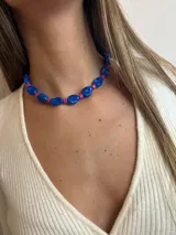 Collar corto con cuentas grandes de color azul y cuentas pequeñas cilíndricas de color fucsia.