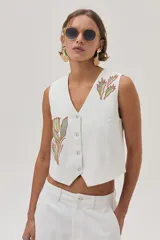 Pantalón barrel color crudo en gabardina 100% algodón, con bordados decorativos en ambas piernas.