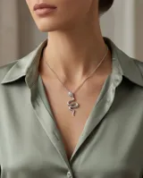 Collar de cadena fina de acero con baño de plata y dije colgante en forma de serpiente con detalle de piedra brillante en la cabeza.