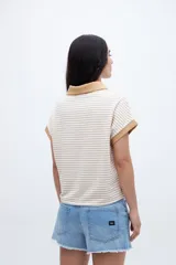 Remera con cuello tipo polo y escote en V, a rayas horizontales color beige y blanco, con cuello y mangas color beige liso.