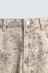 Pantalón de corte baggy fit confeccionado en tejido de algodón con efecto lavado y estampado abstracto en tonos beige y gris. Presenta diseño de cinco bolsillos, cierre frontal con cremallera y botón.
