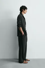 Pantalón de corte relajado confeccionado en una mezcla de lino y viscosa. Presenta bolsillos delanteros, bolsillos traseros de plastrón y cierre frontal con cremallera y botón.