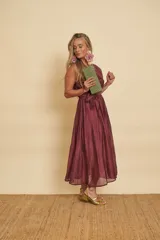 Vestido midi color bordó con tirantes anchos, escote redondo y lazo para ajustar en la cintura.