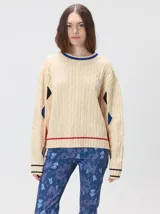 Sweater de punto con diseño de ochos en color verde, cuello redondo con detalle de franja en contraste, y apliques de rombos en las mangas. Presenta un bordado con la letra M en el pecho.