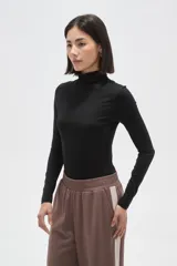 Polera de poliamida ajustada al cuerpo, con cuello alto y mangas largas.