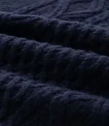 Chaleco de punto sin mangas con escote en V y aberturas laterales. Presenta una textura de tejido trenzado y un corte alargado, ideal para superposiciones.