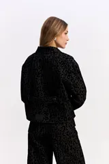 Campera de corte clásico con cuello camisero y cierre frontal de botones, confeccionada en tejido de algodón con textura en relieve de animal print.