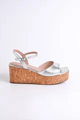 Sandalias plateadas con plataforma de corcho, tira delgada en el tobillo y plantilla cuadrada.