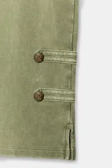 Pantalón capri verde militar de tiro medio, confeccionado en hilatura de algodón con acabado lavado. Presenta cintura elástica y detalles de alamares con botones en los bajos.