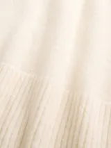 Buzo de punto con cuello en V, manga larga y puños acanalados. Diseño holgado y minimalista.