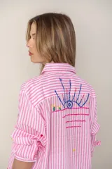 Camisa blanca de manga larga con bordados de motivos playeros.