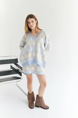 Sweater oversize con cuello en V y estampado de rombos en tonos lila, rosa y rojo. Tejido de lana artesanal.