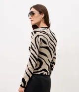 Suéter de punto Cortelle con estampado de cebra en tonos beige y negro, cuello redondo acanalado y mangas largas con puños elásticos.