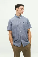 Camisa de manga corta confeccionada en una mezcla de lino y algodón, con cuello abotonado y bolsillo frontal con logo bordado.