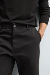 Pantalón de corte recto confeccionado en tejido de sarga con estructura diagonal. Presenta cintura elástica, bolsillos delanteros, bolsillos traseros de vivo y cierre frontal con cremallera y botón.