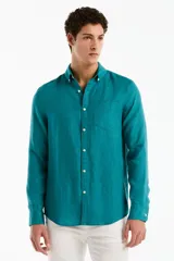 Camisa de lino de manga larga color verde turquesa, con cuello camisero, cierre frontal de botones y un bolsillo ojal en el pecho.
