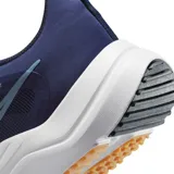 Championes de running Nike Downshifter 12, color negro con detalles en rojo y suela blanca. Presentan el logo de la marca en el lateral y un diseño ligero y transpirable.