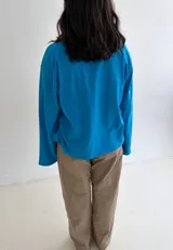 Remera oversize de manga larga y ancha, color celeste, confeccionada en algodón con cuello redondo.