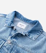 Campera de jean en color azul con efecto desgastado, cuello clásico, cierre frontal con botones metálicos y dos bolsillos con solapa en el pecho.