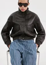 Pantalón estilo tejano vaquero de algodón con diseño largo y recto, tiro medio y estampado de rayas. Cuenta con dos bolsillos laterales y cierre de lazo en la cintura.