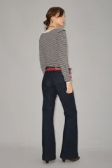 Jean de corte recto y tiro medio, confeccionado en denim azul oscuro de acabado raw. Presenta un diseño clásico de cinco bolsillos con costuras reforzadas y cierre frontal con botón y cremallera.