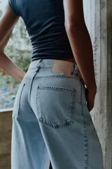 Jeans de tiro alto con cinco bolsillos y diseño de costuras verticales en el frente. Cierre frontal con cremallera y botón.