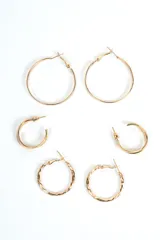 Set de tres pares de aros tipo argolla dorados, de diferentes tamaños y diseños: un par grande de aro fino liso, un par mediano de aro más ancho y liso, y un par pequeño con textura retorcida.