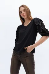 Remera negra de lyocell y algodón, con mangas cortas con volados con contraste de color.