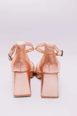 Sandalias de cuero color cobre con plataforma y taco cuadrado. Tiras cruzadas sobre el empeine y pulsera con hebilla al tobillo.