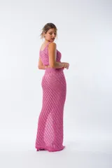 Pollera midi de tejido de punto con diseño acanalado diagonal, tiro alto y tajo lateral profundo. Presenta un acabado con flecos en el ruedo.