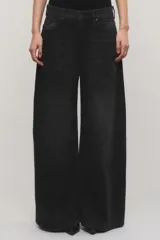 Jeans de tiro medio confeccionado en 100% algodón sin elasticidad, con diseño de pierna amplia y fluida, bolsillos plaqué delanteros y efecto de lavado oscuro con quiebres localizados.