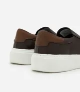 Championes tipo slip-on de cuero marrón con detalle de talón en tono contrastante y suela de goma blanca.