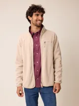 Campera de polar color beige con cierre frontal completo, cuello alto y bolsillo en el pecho con cierre y detalle de tejido técnico.
