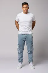 Pantalón jean celeste, corte jogger, con bolsillos cargo laterales y puños elásticos en los tobillos.