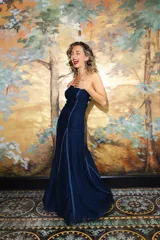Vestido largo strapless de encaje negro con transparencias y espalda descubierta con tiras cruzadas, de corte entallado y falda de caída suelta.