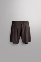 Pantalones cortos de entrenamiento 2 en 1 de color marrón, confeccionados por Zara Athleticz en tejido técnico ligero y elástico con malla interior. Cuenta con cintura elástica ajustable con cordón y bolsillos laterales.