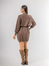 Vestido tipo polerón de tejido de punto color borgoña, con cuello alto, mangas largas con puños ajustados y corte recto. Incluye un cinturón del mismo material con una hebilla decorativa de flor con cristales.