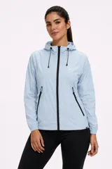 Campera cortaviento celeste con capucha ajustable, cierre frontal y bolsillos laterales con cierres negros contrastantes.
