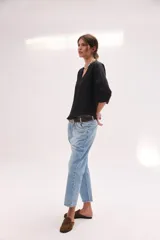 Blusa de lino color lila, de corte relajado y mangas largas amplias, con escote en V y ruedo curvo.