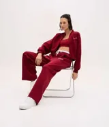 Pantalón deportivo de corte recto, confeccionado en tejido de microfibra color bordó. Presenta cintura elástica con cordón ajustable, bolsillos delanteros embutidos y detalle de bordado discreto en la pierna.