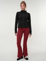 Campera deportiva marrón con cuello alto y cierre frontal completo. Presenta mangas largas con orificio para el pulgar y corte ajustado.