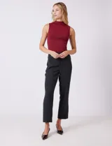 Pantalón de vestir de corte recto y tiro medio-alto, confeccionado en tela sastrera. Presenta cierre frontal con botón, presillas para cinturón y detalles de botones decorativos en carey en la cintura. Incluye bolsillos laterales funcionales y pinzas traseras para un ajuste estilizado.