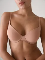 Soutien armado con aro en color beige, confeccionado en microfibra suave de efecto segunda piel. Cuenta con copas preformadas, breteles ajustables y cierre posterior con ganchos de ajuste múltiple.