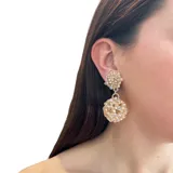 Aros colgantes con dos esferas tramadas en cristales color dorado.