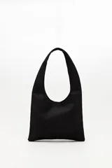 Cartera tipo hobo confeccionada en gamuza negra, con asa integrada y decorada en toda su superficie con tachas metálicas plateadas dispuestas en patrones geométricos.